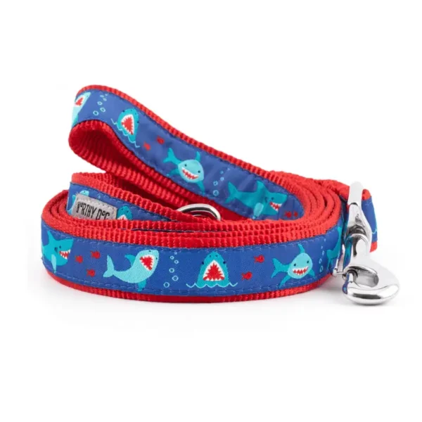 A dog leash featuring a blue background with shark graphics and a red trim.