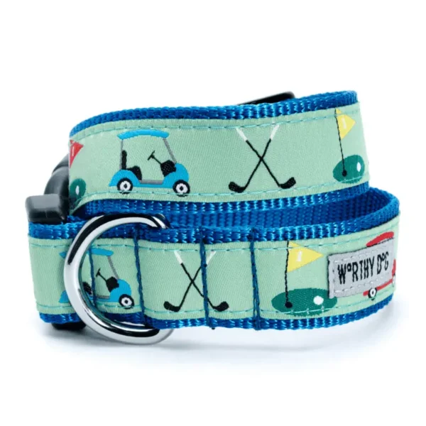 A dog collar featuring a golf-themed design with golf carts, clubs, and flags on a green background. The collar has a blue trim and a metal D-ring.
