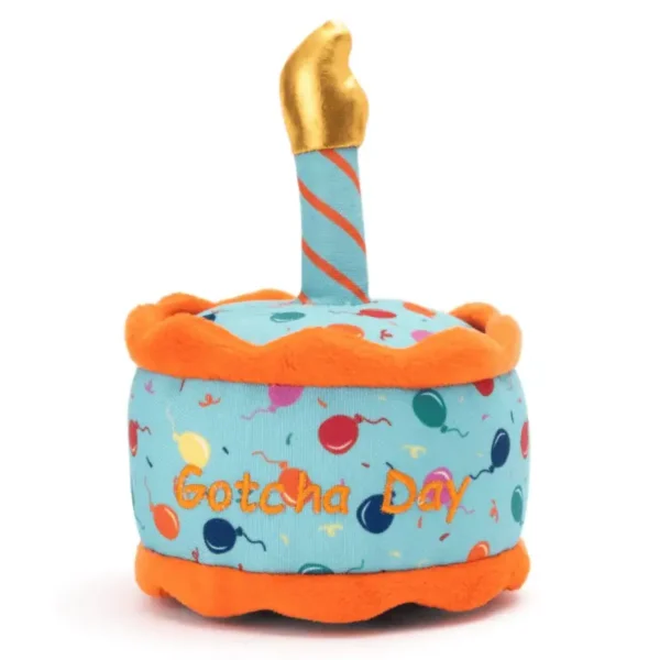 A plush cake dog toy with the text "Gotcha Day," featuring colorful dots and a candle on top.