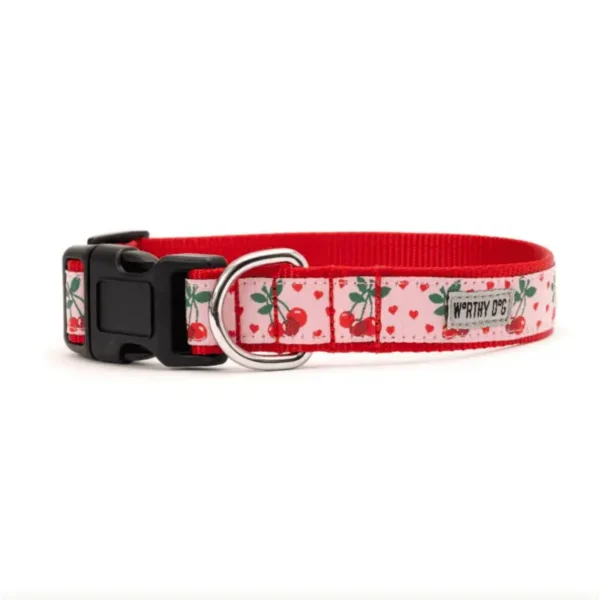 A pink dog collar with a cherry-patterned design.
