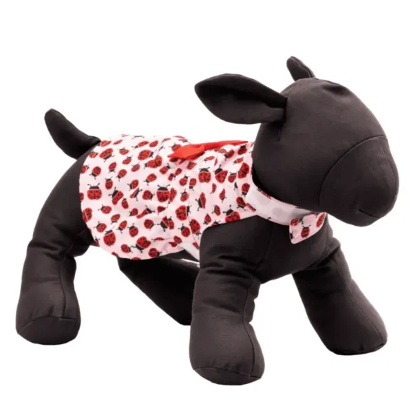 A plush dog mannequin wearing a patterned dog dress with a red and white design.