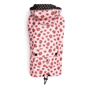 A dog raincoat with a ladybug pattern and a black polka dot lining.