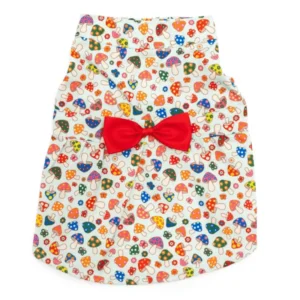 A colorful dog dress with a pattern of mushrooms and a red bow.