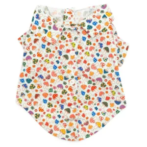 A short-sleeved dog shirt featuring a colorful pattern of small mushrooms, flowers, and hearts on a light background.