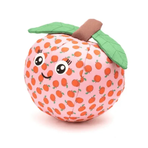A plush dog toy shaped like an peach, featuring a smiling face and green leaves on top.