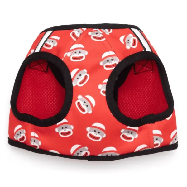 A red dog harness vest featuring a pattern of smiling sock monkey faces.
