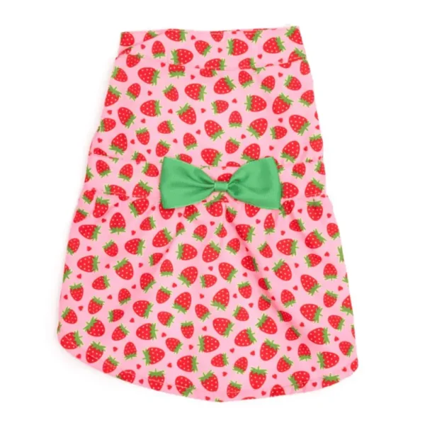 A pink dog dress patterned with strawberries and featuring a green bow at the waist.