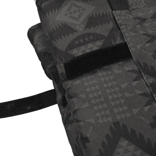 Close-up of a black patterned fabric with straps and a fastening mechanism.