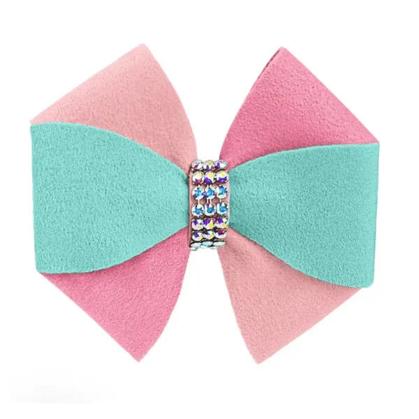 A two-toned dog bow hair accessory, featuring pink and turquoise colors, with a rhinestone embellishment at the center.