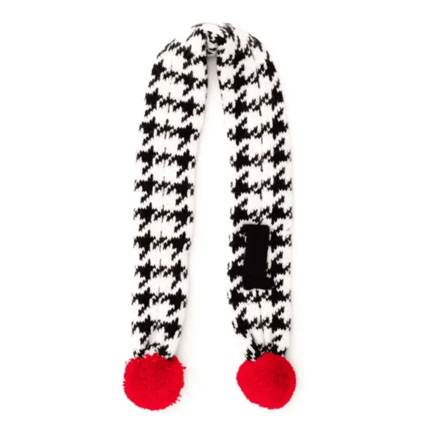 A black and white houndstooth-patterned dog scarf with red pom-poms at each end.