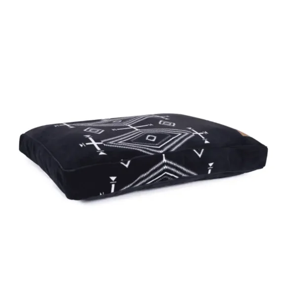 A black decorative dog bed with a tribal geometric white pattern.