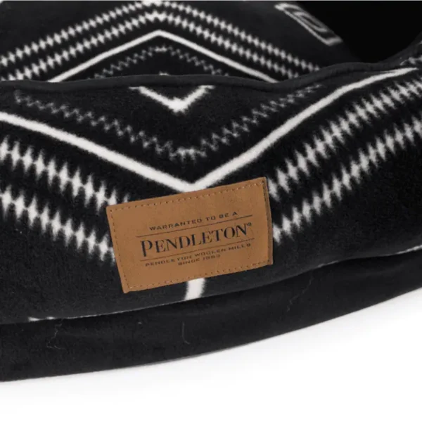 A close-up of a black and white geometric-patterned fabric with a Pendleton label.