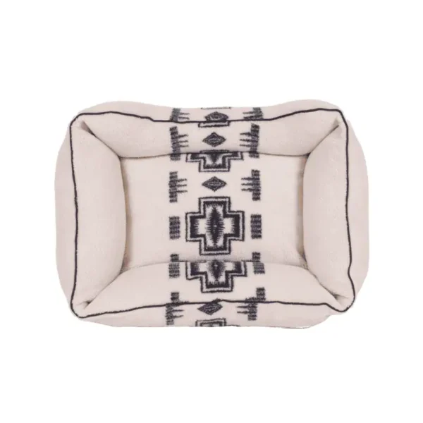 A rectangular dog bed with a geometric cream and black design.