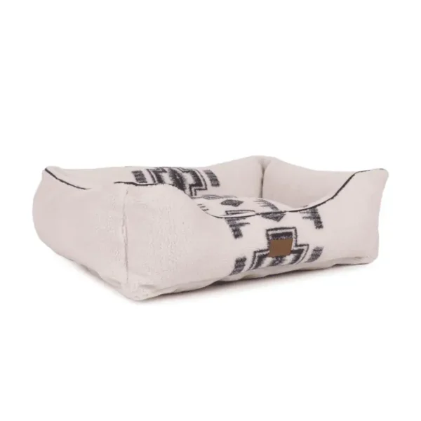 A soft, rectangular dog bed with a tribal patterned design in cream and black.