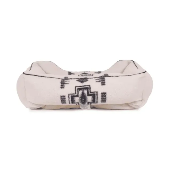 A decorative dog bed with a tribal pattern in beige and black.