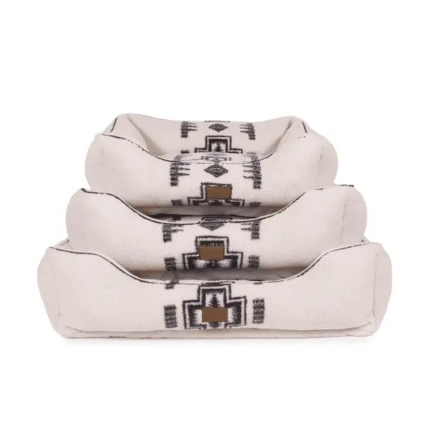 Three stacked cream dog beds with a black geometric tribal design.