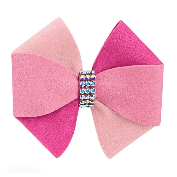 A large, decorative dog hair bow made of soft pink and fuchsia Ultrasuede, accented with a rhinestones-encrusted center.