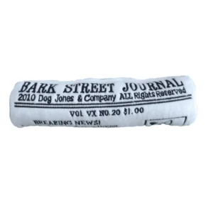 Plush white Bark Street Journal dog toy shaped like a rolled-up newspaper with black embroidered wording: “Bark Street Journal 2010 Dog Jones & Company All Rights Reserved Vol VX NO. 20 $1.00 Breaking News!” Soft squeaky toy for playful pups.