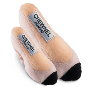 Plush light pink Chewnel “Tie Me In Knots” high heel dog toy with black tips, silver label embroidered with black “CHEWNEL France” and paw print. Soft squeaky toy for stylish pups.