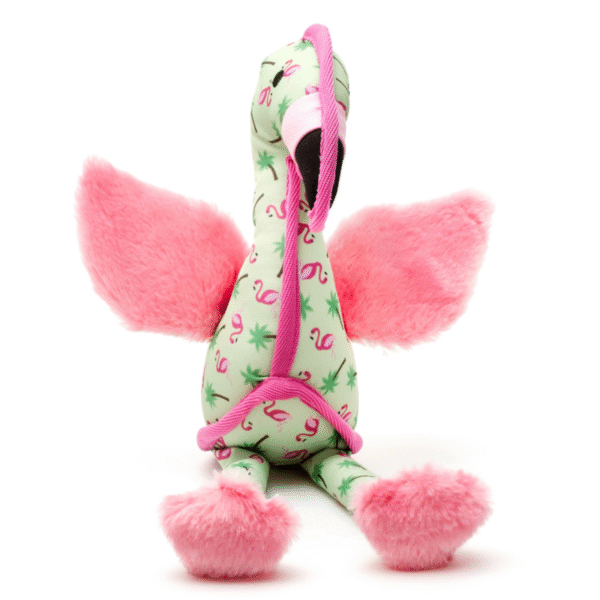 Plush pink flamingo dog toy sitting upright with fuzzy wings, palm tree and flamingo print, and soft feet for playtime.