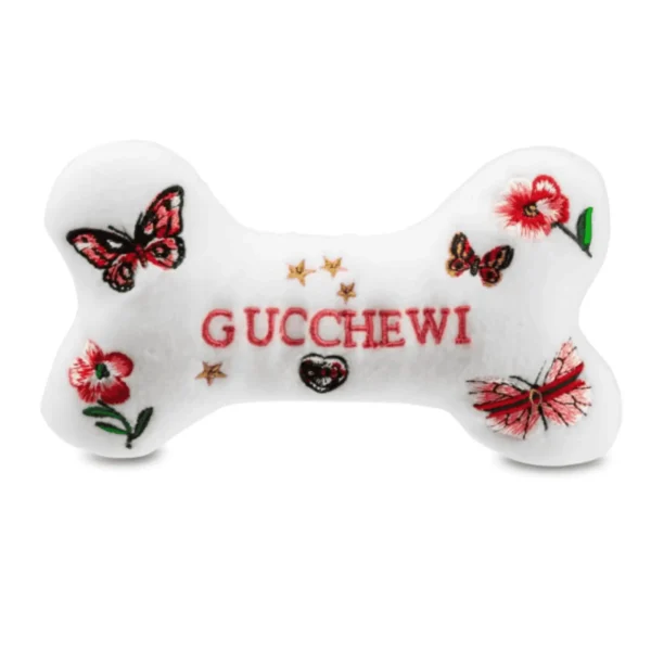 White plush bone dog toy with embroidered flowers, butterflies, and Gucchewi text